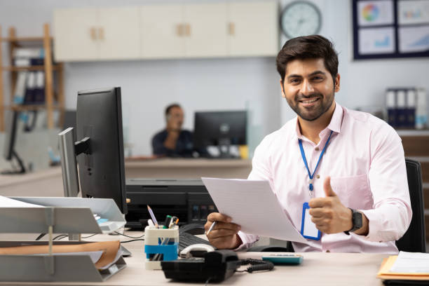 businessman with computer reading documents in office